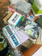 Sun visor phone holder packaging on a cluttered surface with a digital scale.